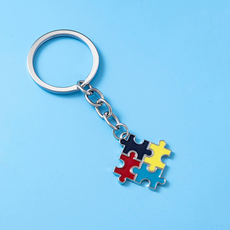 Keychain with colorful puzzle piece charm on blue background for sensory needs awareness