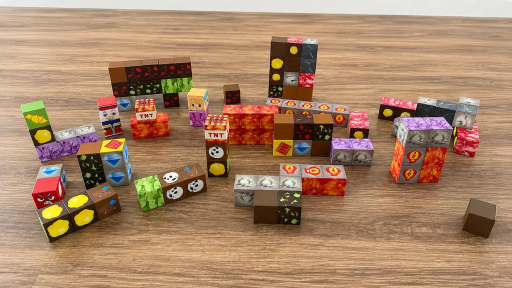 A collection of Minecraft-themed building blocks and small cubes arranged on a wooden tabletop