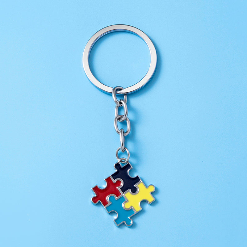 Metal keychain with colorful puzzle piece charm on blue background