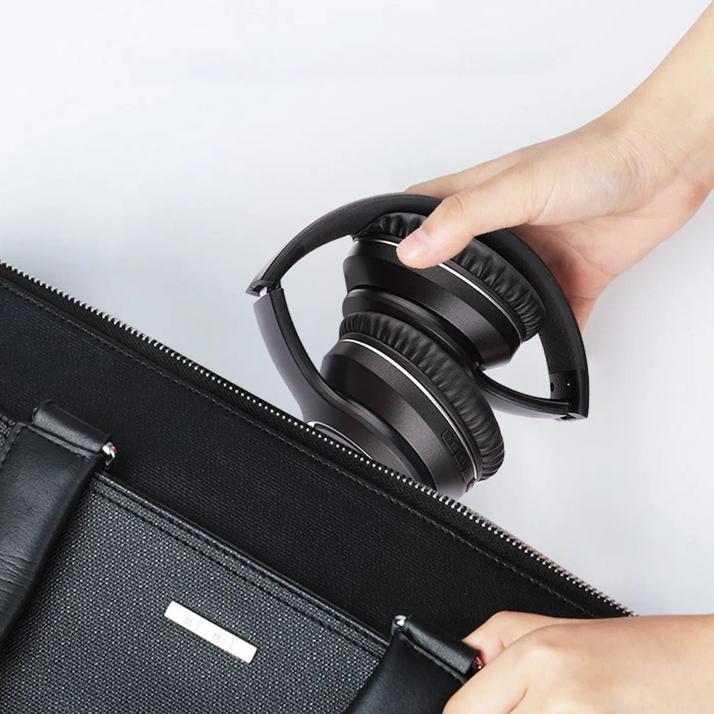Person placing a pair of black headphones into a black carrying case 
