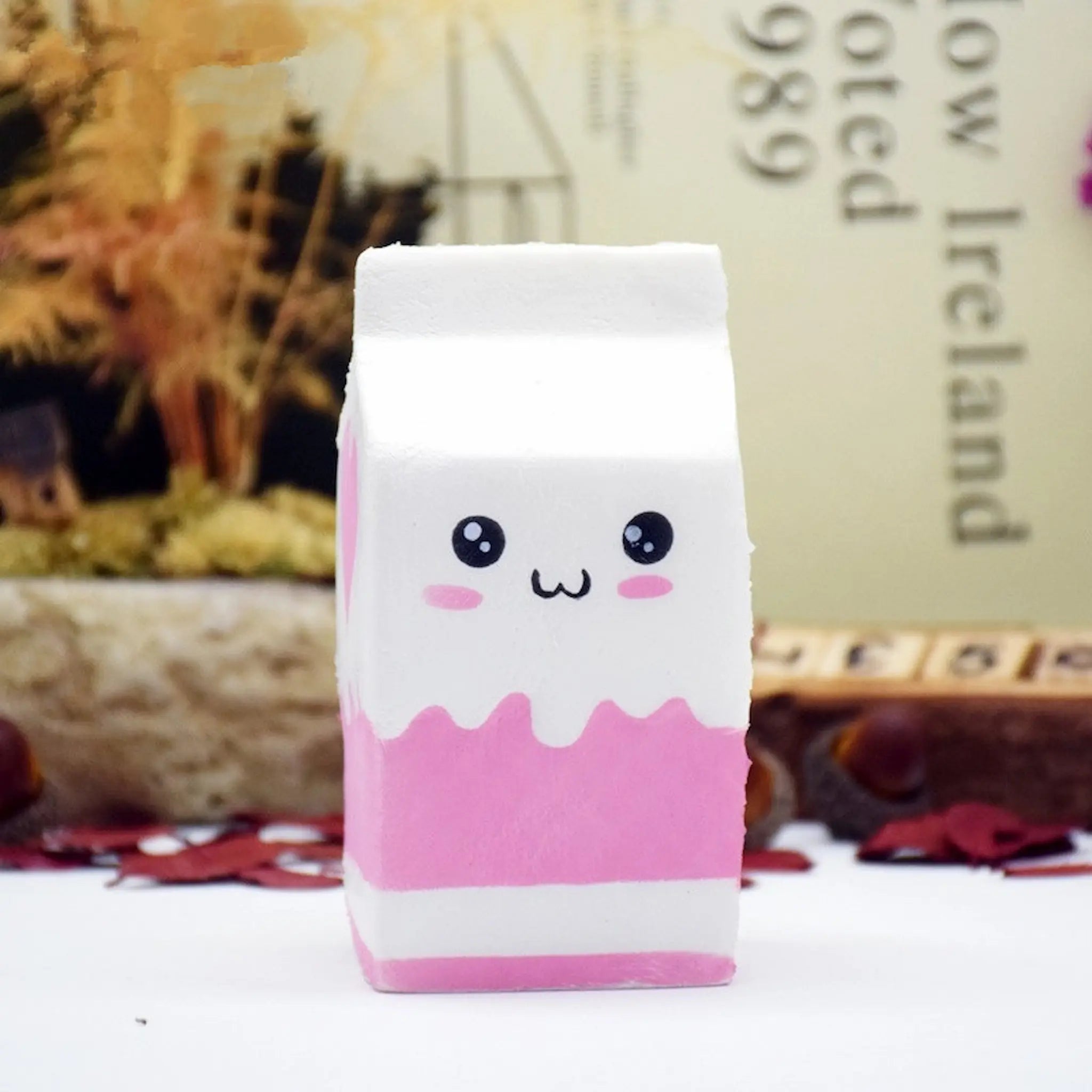 Pink and white container with a cute face design on a blurred background